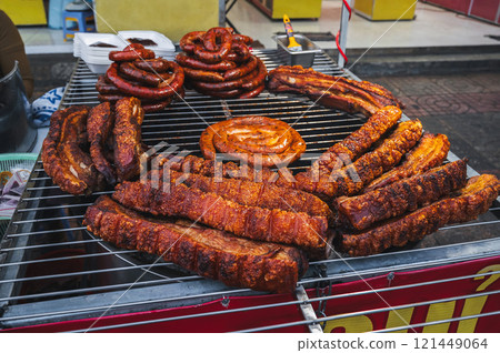 Pork sausage and meat, cooked on a barbecue grill. 121449064