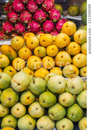 A colorful fruit display case made of mangoes and dragon fruit on display at the local market A colorful fruit display case made of mangoes and dragon fruit on display at the local market 121449099