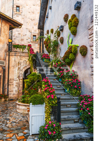 Summer flowers in pots decorating the steps and walls and houses Summer flowers in pots decorating the steps and walls and houses 121449132