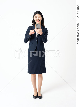 一個穿著西裝的年輕女人拿著智能手機 121449826