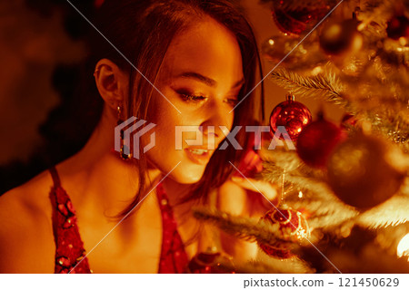 Woman admiring Christmas tree decorations. 121450629
