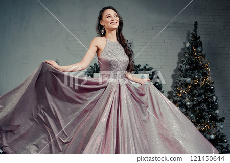 Smiling Woman Showcasing Elegant Sparkling Gown. Smiling Woman Showcasing Elegant Sparkling Gown. 121450644
