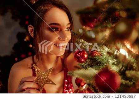 Happy woman holding golden star ornament. Happy woman holding golden star ornament. 121450687