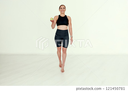 Trainer Holding Tennis Ball with a Smile. 121450781