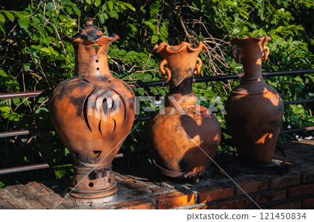 Vintage clay jugs and vases decorate Asian garden in summer Vintage clay jugs and vases decorate Asian garden in summer 121450834