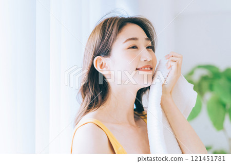 一個女人用毛巾擦臉 121451781