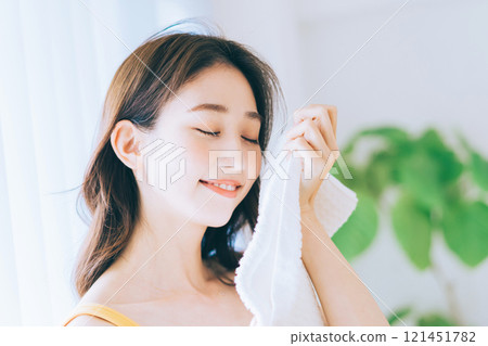 A woman wiping his face with a towel 121451782