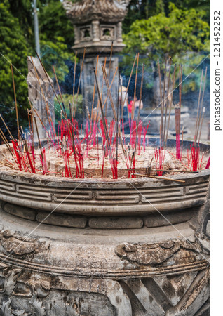 Smoking incense sticks on Buddhist pagoda close-up 121452252