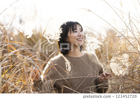 A woman strolling through silver grass 121452720