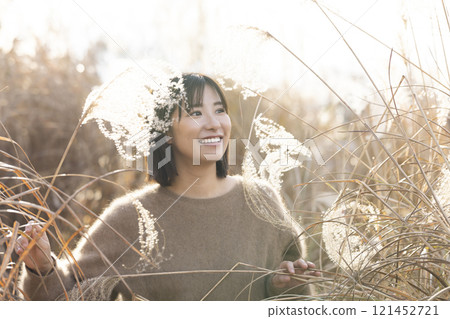 A woman strolling through silver grass A woman strolling through silver grass 121452721