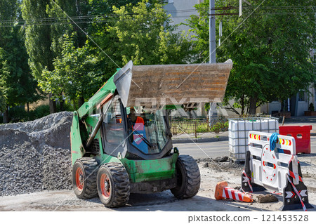Heavy machinery in action at a construction site during midday 121453528