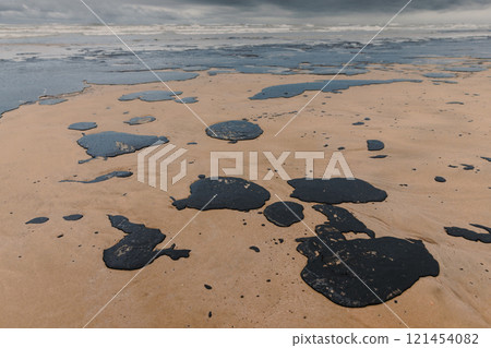 Oil leak in coastline after a tanker wreck. Fuel oil polluted and destroying beach 121454082