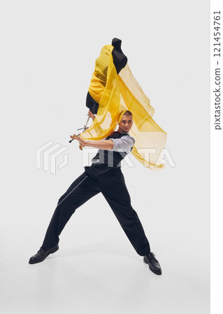 Young man, fashion designer energetically dancing of joy and happiness with mannequin against white studio background. Wide angle shot. Young man, fashion designer energetically dancing of joy and happiness with mannequin against white studio background. Wide angle shot. 121454761