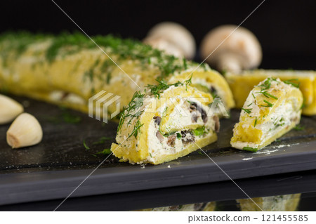 baked potato roll with cottage cheese filling with garlic and mushrooms, isolated on black background baked potato roll with cottage cheese filling with garlic and mushrooms, isolated on black background 121455585