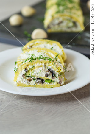 baked potato roll with cottage cheese filling with garlic and mushrooms, on a light wooden table baked potato roll with cottage cheese filling with garlic and mushrooms, on a light wooden table 121455586