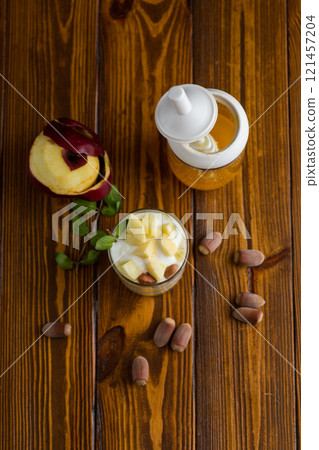 sweet homemade yogurt in a glass with apples, nuts and honey 121457204