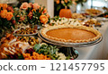 Thanksgiving feast buffet with pumpkin pie, roasted vegetables, and flowers. 121457795