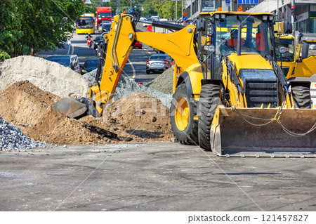 Heavy machinery at work on a busy city street during midday construction. Copy space. 121457827