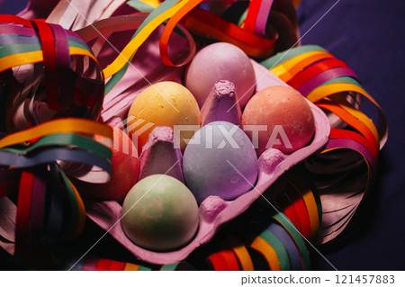 Painted colorful Easter eggs nestled in a violet box flatly. LGBT gay vibrant colors garland. Festive wallpaper, greeting card Festive springtime pic. Painted colorful Easter eggs nestled in a violet box flatly. LGBT gay vibrant colors garland. Festive wallpaper, greeting card Festive springtime pic. 121457883