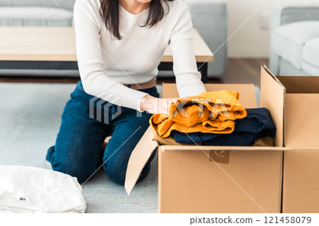 Young woman preparing to move, no face 121458079