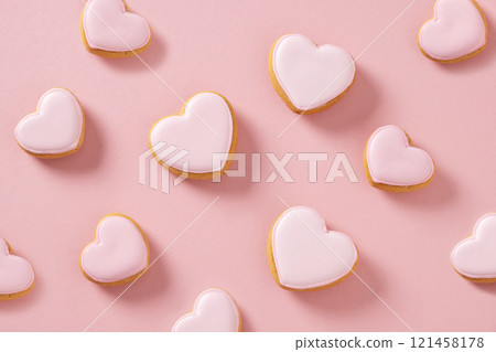 Heart shaped cookies with pink glaze on pink background. Valentines day wallpaper or greeting card. Monochrome abstract pattern. Heart shaped cookies with pink glaze on pink background. Valentines day wallpaper or greeting card. Monochrome abstract pattern. 121458178