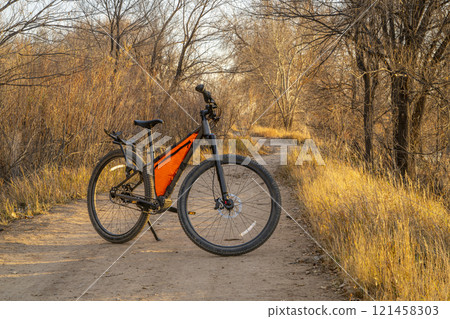 mountain bike on a gravel biking and hiking trail in one of natural areas in Fort Collins, Colorado, late fall scenery at sunset mountain bike on a gravel biking and hiking trail in one of natural areas in Fort Collins, Colorado, late fall scenery at sunset 121458303