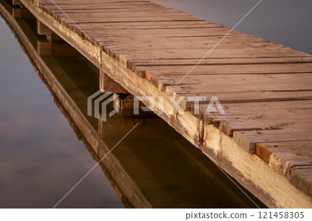 wooden footbridge over a lake in sunset light wooden footbridge over a lake in sunset light 121458305