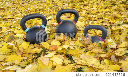 heavy exercise kettlebells in fall color leaves - outdoor fitness concept 121458316