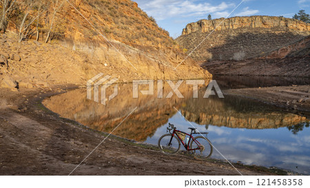 gravel bike on a shore of Horsetooth Reservoir in Colorado with sandstone cliff reflections 121458358