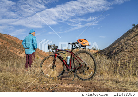senior cyclist with a gravel bike in Colorado foothills overlooking Horsetooth Reservoir senior cyclist with a gravel bike in Colorado foothills overlooking Horsetooth Reservoir 121458399