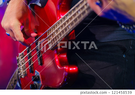 Close-up of musician playing electric bass guitar on stage 121458539