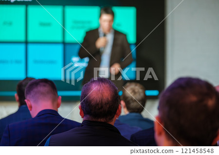 Business professionals attentively watching presentation during corporate conference 121458548