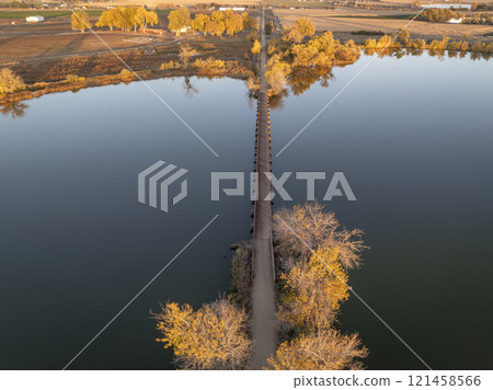 long footbridge over Roulard Lake near Severance, Colorado in fall scenery - Great Western Bike Trail, rails to trails conversion project 121458566