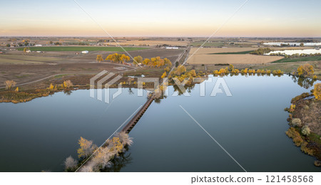 long footbridge over Roulard Lake near Severance, Colorado in fall scenery - Great Western Bike Trail, rails to trails conversion project 121458568
