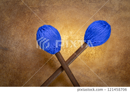 marimba mallets against backlit drum goat skin 121458706