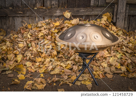 handpan drum on a stand outdoors, a modern, melodic percussion instrument made of steel, known for its soothing, resonant tones 121458729