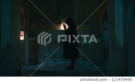 Silhouette Of The Dark Monk Praying In The Night Church  121459499