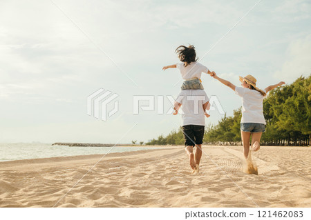 Happy family in holiday. Father, Mother and kids having fun together shoulder ride and running on summer beach, Parents carrying children on neck, family is enjoying their summer in sunset time Happy family in holiday. Father, Mother and kids having fun together shoulder ride and running on summer beach, Parents carrying children on neck, family is enjoying their summer in sunset time 121462083