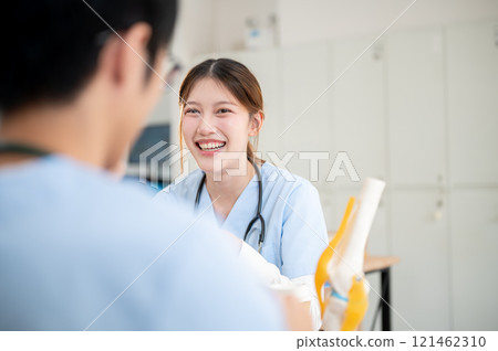 A positive Asian female medical student is studying with her male classmate in the library. A positive Asian female medical student is studying with her male classmate in the library. 121462310
