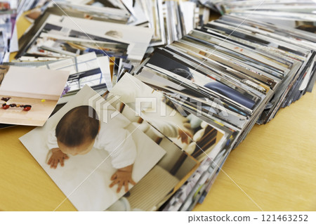 Many photo prints stacked on a table 121463252