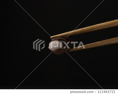 用筷子夾起煮好的花豆。 用筷子夾起煮好的花豆。 121463715