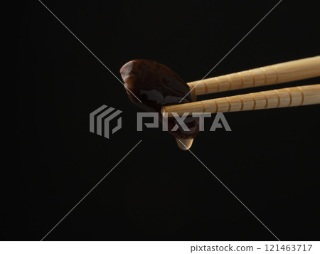 Picking up boiled beans with chopsticks 121463717