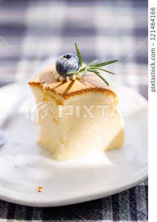 a piece of cheese cake on checked pattern table. 121464166