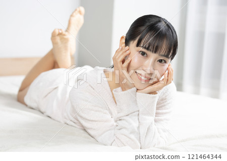 清晨穿著睡衣躺在床上的年輕女子 清晨穿著睡衣躺在床上的年輕女子 121464344