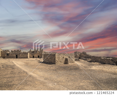 Ruins of Azraq Castle (Qasr al-Azraq) is a crusader castle (300AD),  central-eastern Jordan, 100 km east of Amman, Jordan. Against the background of a beautiful sky with clouds 121465224