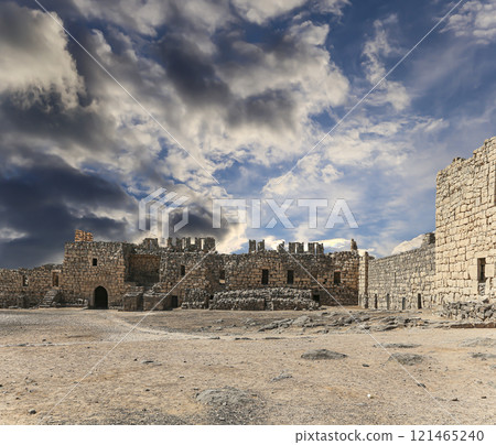 Ruins of Azraq Castle (Qasr al-Azraq) is a crusader castle (300AD),  central-eastern Jordan, 100 km east of Amman, Jordan. Against the background of a beautiful sky with clouds 121465240