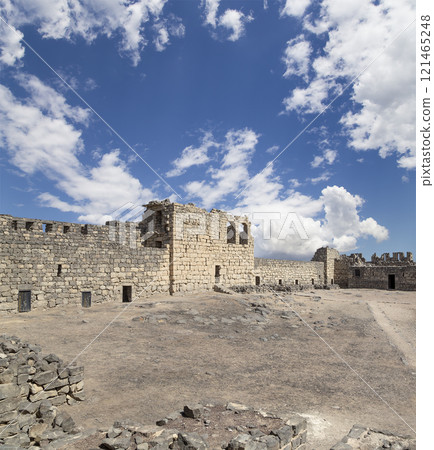 Ruins of Azraq Castle (Qasr al-Azraq) is a crusader castle (300AD),  central-eastern Jordan, 100 km east of Amman, Jordan. Against the background of a beautiful sky with clouds 121465248