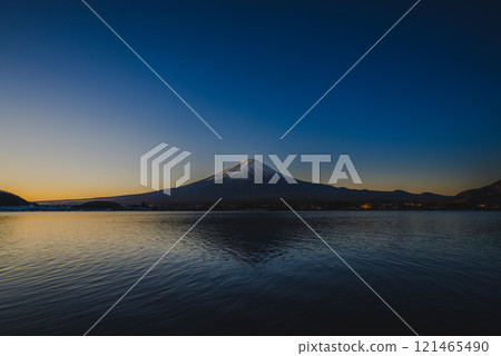 Sunrise over Mt. Fuji reflected on the lake surface from the shores of Lake Kawaguchi 121465490