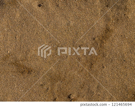 Golden brown sandy beach surface with small pebbles and subtle patterns Golden brown sandy beach surface with small pebbles and subtle patterns 121465694