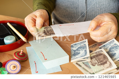 Elderly people preparing New Year's gifts; Grandmother preparing New Year's gifts for her grandchildren; Scrape money out of her pension 121465985